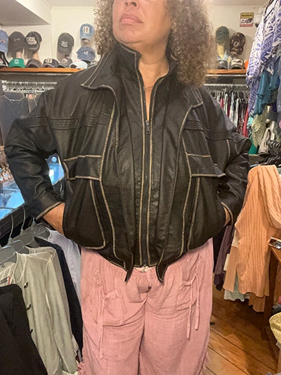 Model wearing brown oversized pocket biker jacket with gold trim, styled with pink size inclusive capri pants
