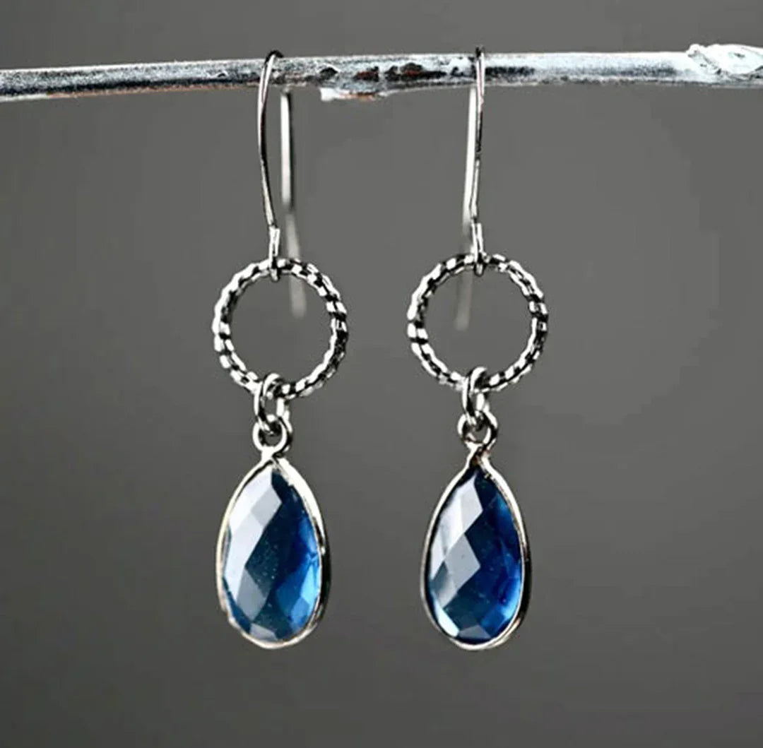 Gunmetal circle earrings with textured hoops and blue teardrop crystal drops