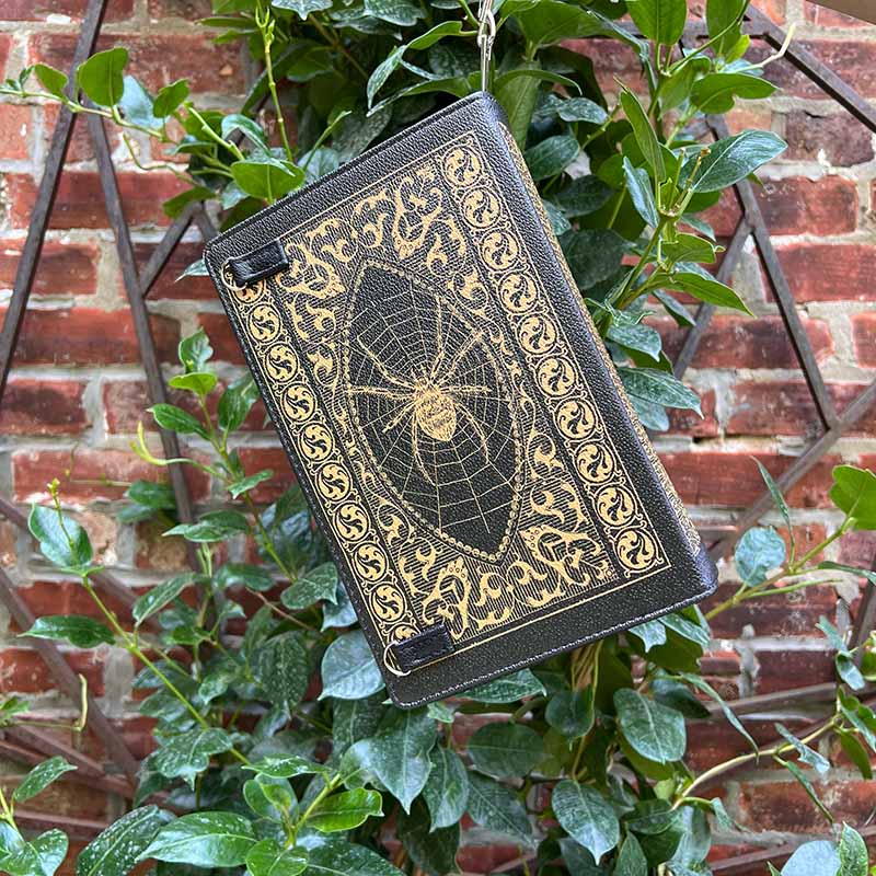 Front of Book of Spells storybook purse , with a graphic of a spider on a spiderweb