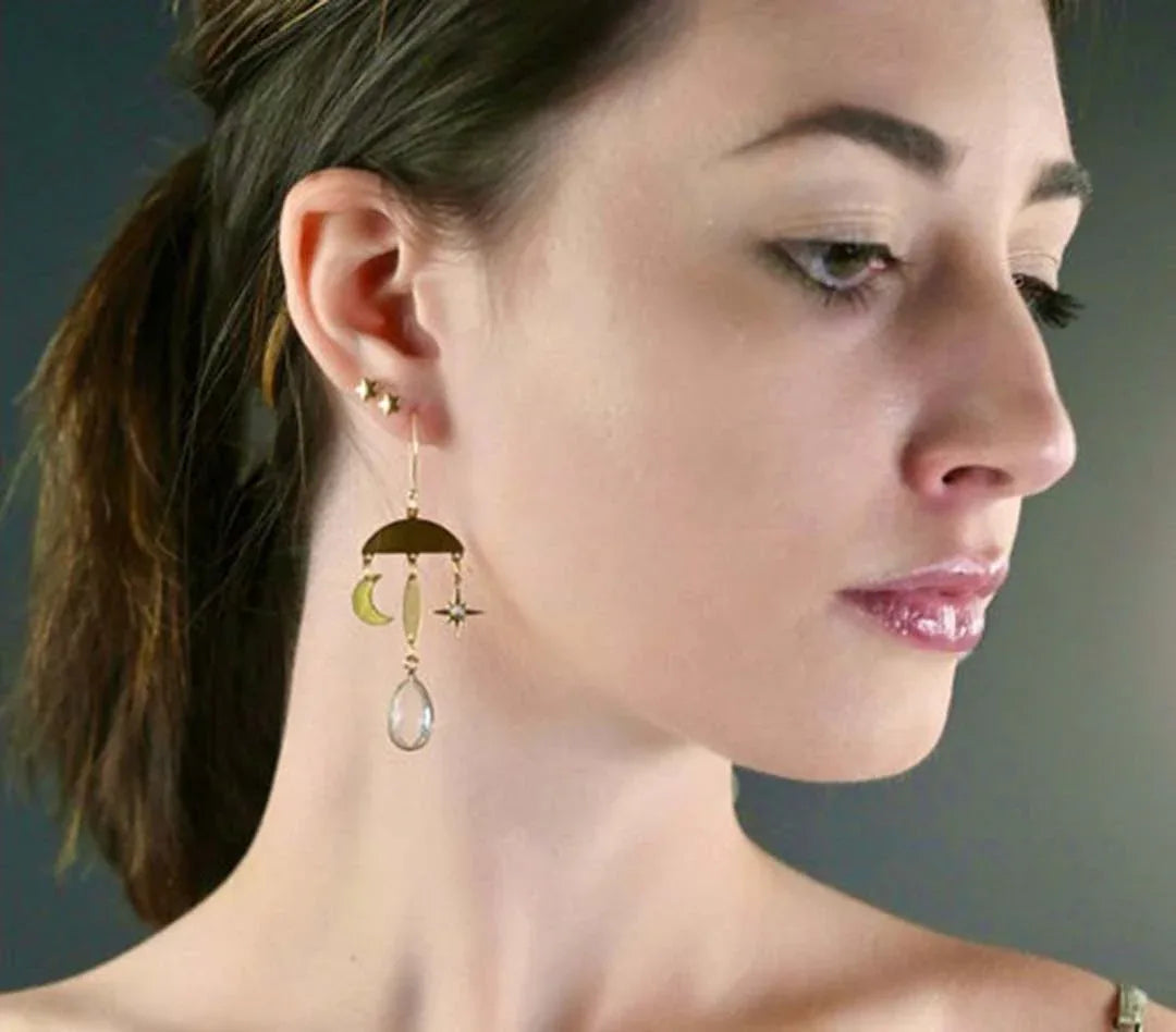 Star and moon drop earrings on model, with clear teardrop crystal quartz dangles