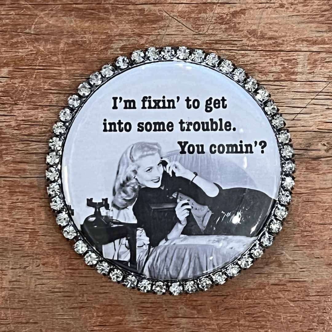 Round magnet with vintage-style image and text on a wooden surface