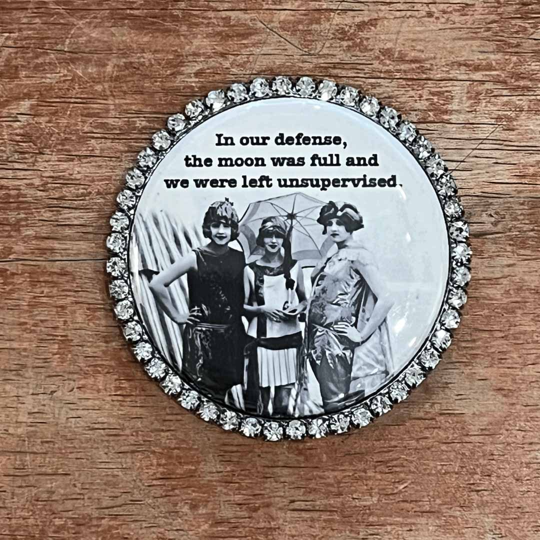 Round magnet with vintage photo and text on a wooden surface