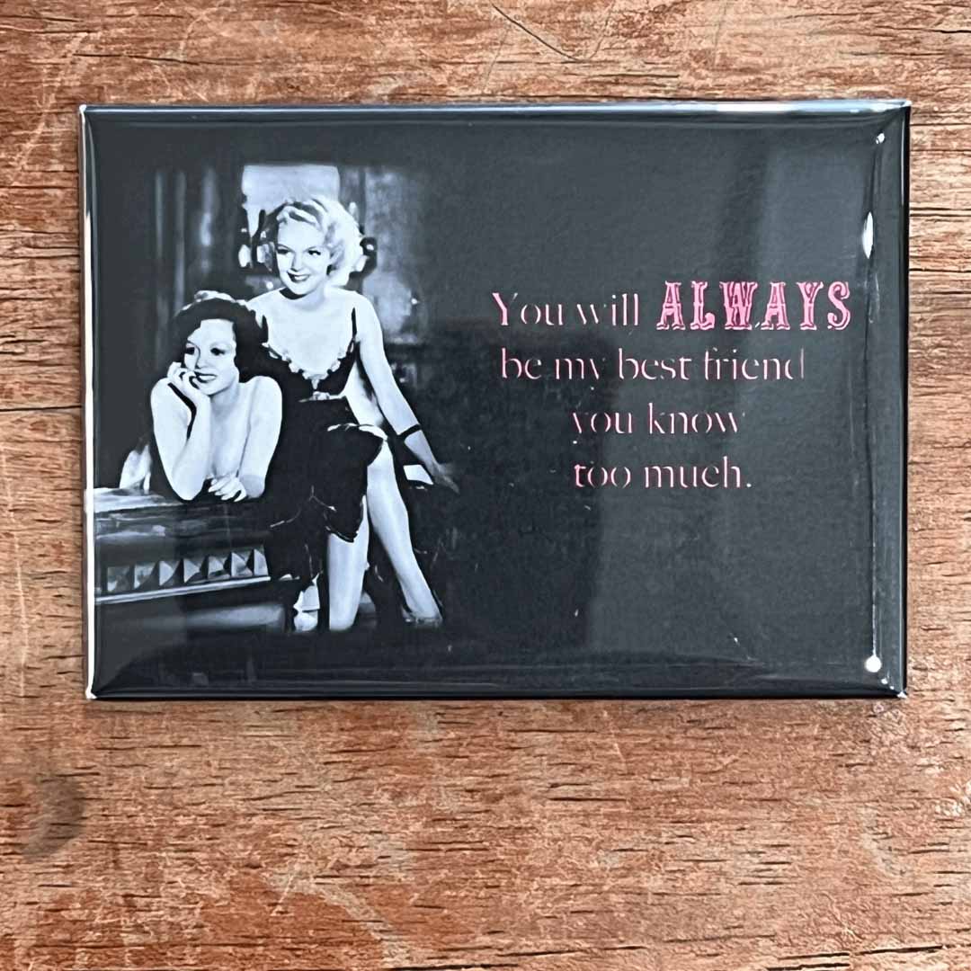Fridge magnet with black and white photo of two women and text on a wooden surface