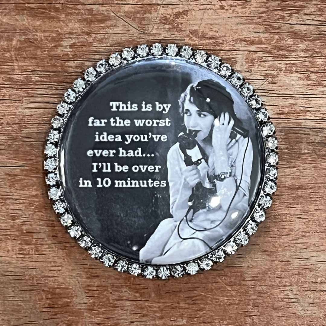 Round decorative magnet with a vintage-style woman and humorous quote on a wooden surface