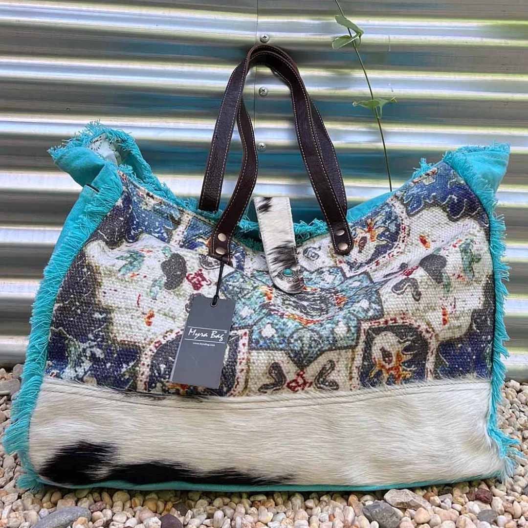 Vibrant oversized, upcycled canvas and leather weekender bag infant of aluminum background