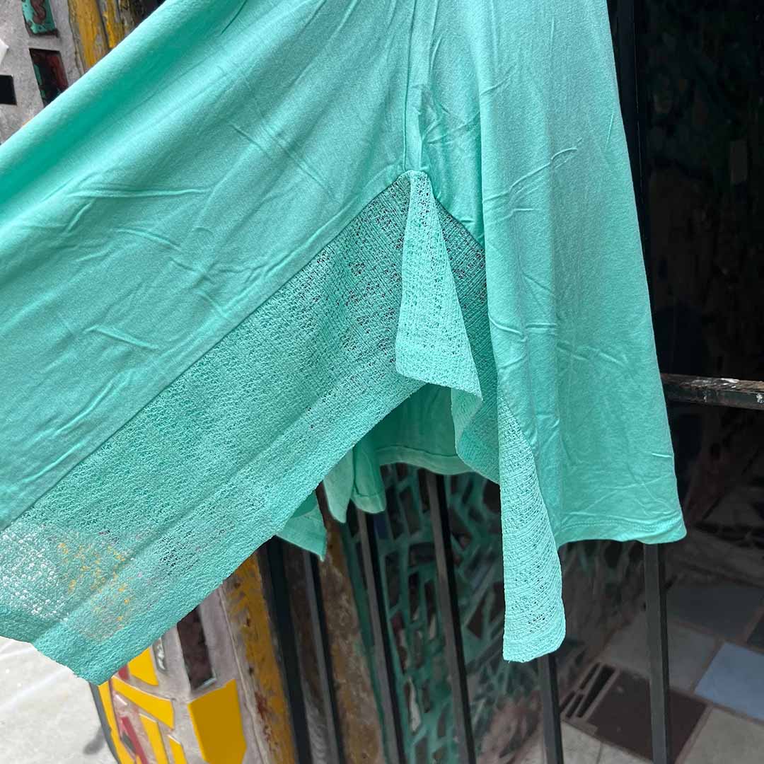 Seafoam green tunic dress close-up of draped hem and side gathered panel