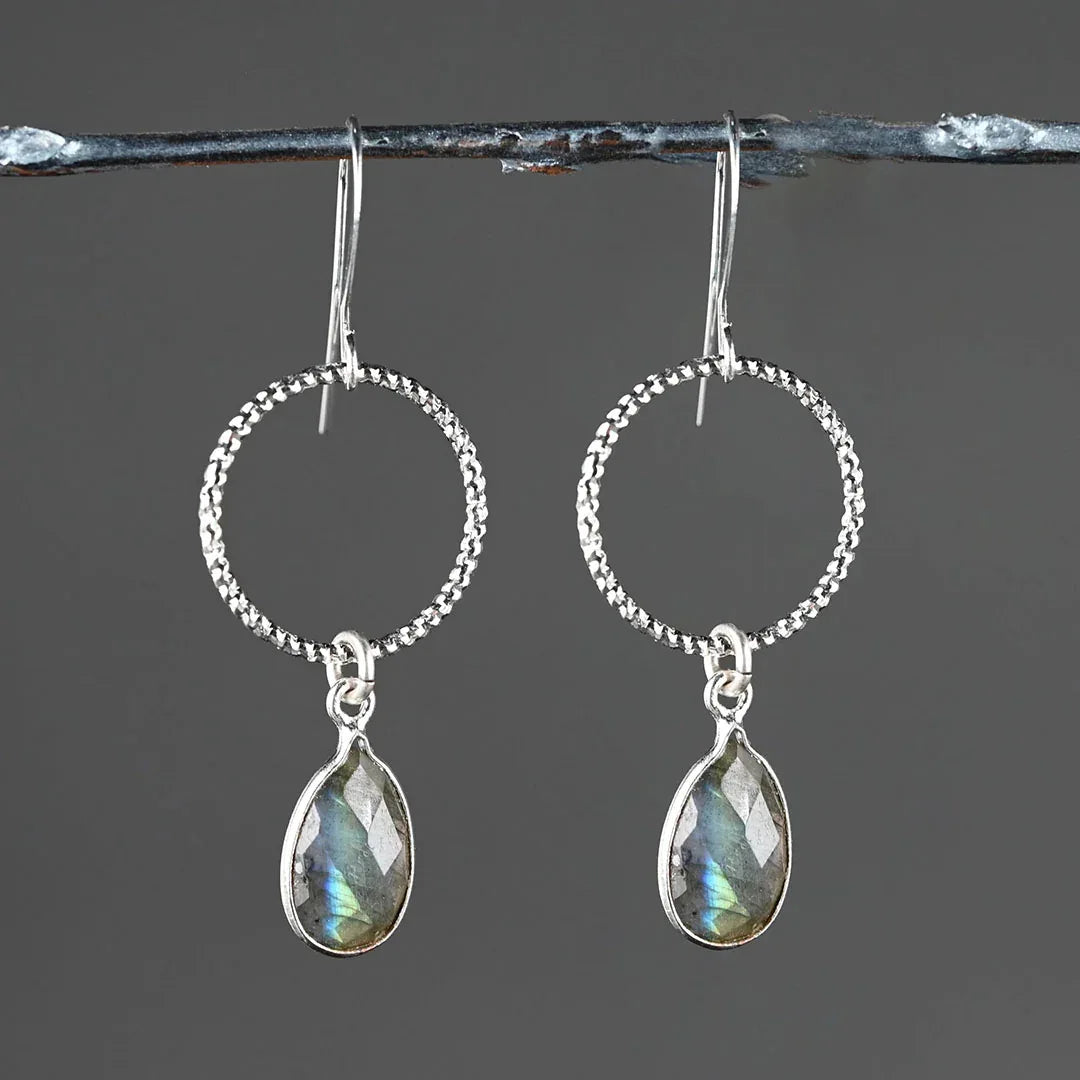 Silver circle hoop earrings with clear quartz teardrop dangles, faceted stones