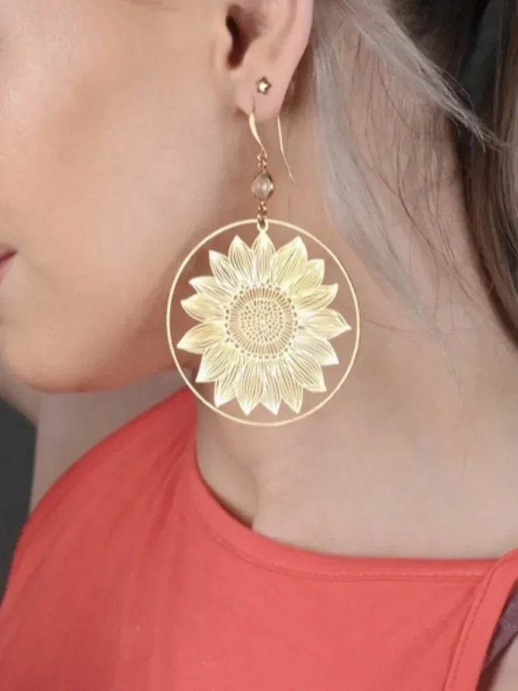 Sunflower hoop earrings on model: large gold floral medallion with crystal drop