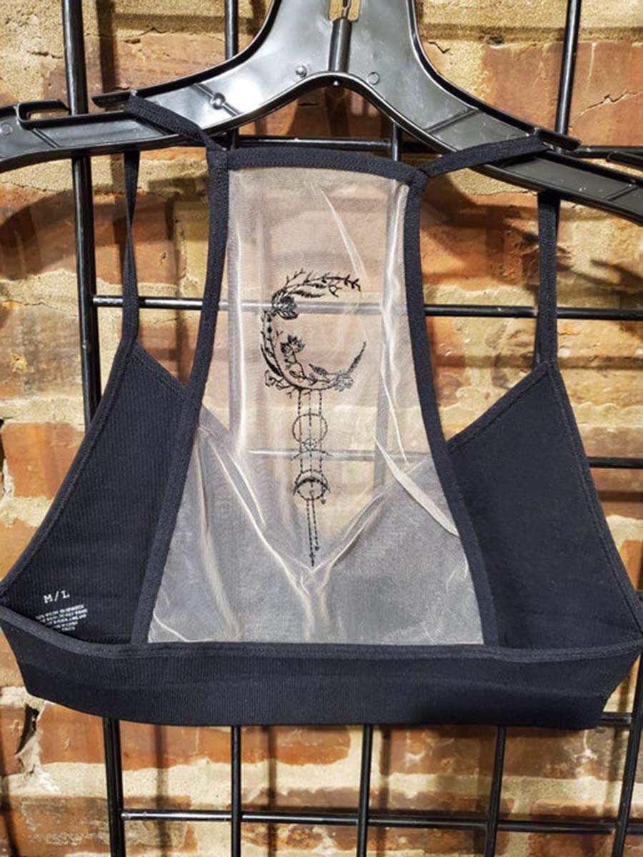 Black bralette, M/L size label, sheer front panel with crescent-and-floral tattoo art