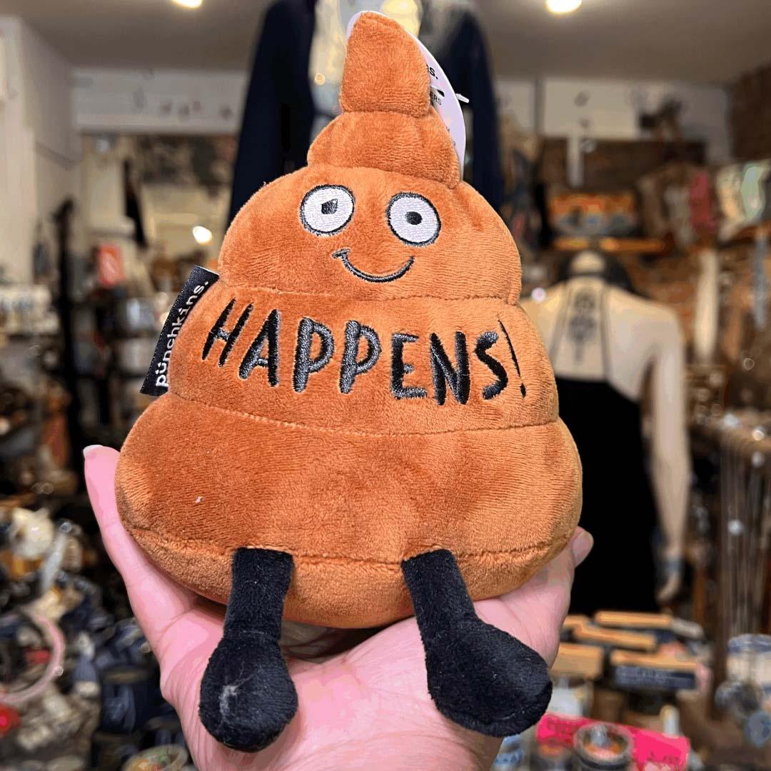 Orange poop emoji plush with smiling face and 'HAPPENS!' text