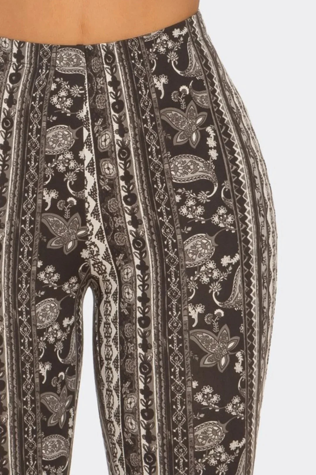 Close-up: black and white flare pant waistband and vertical ornate print stripes