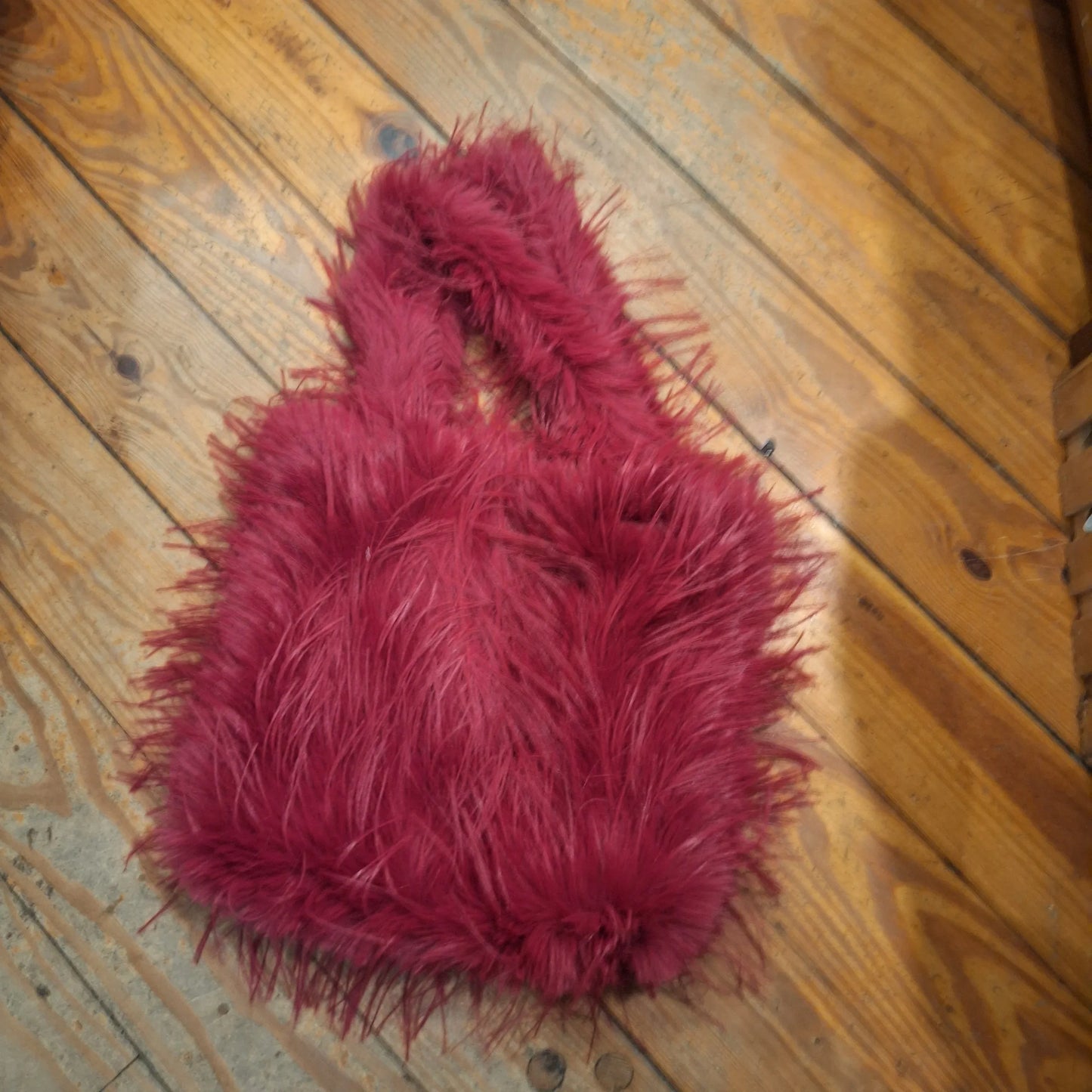 Magenta/fuchsia fuzzy pouch-style fur piece with shaggy texture and round shape