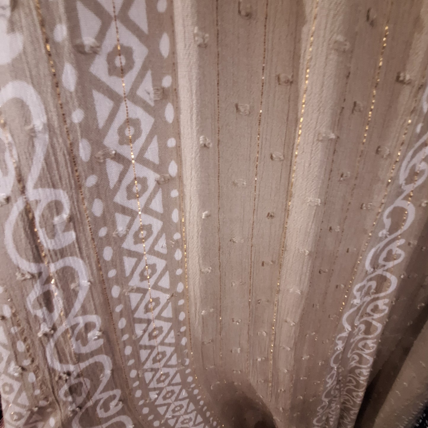 Adjustable jumpsuit fabric detail: cream base with white patterned trim and gold pinstripes