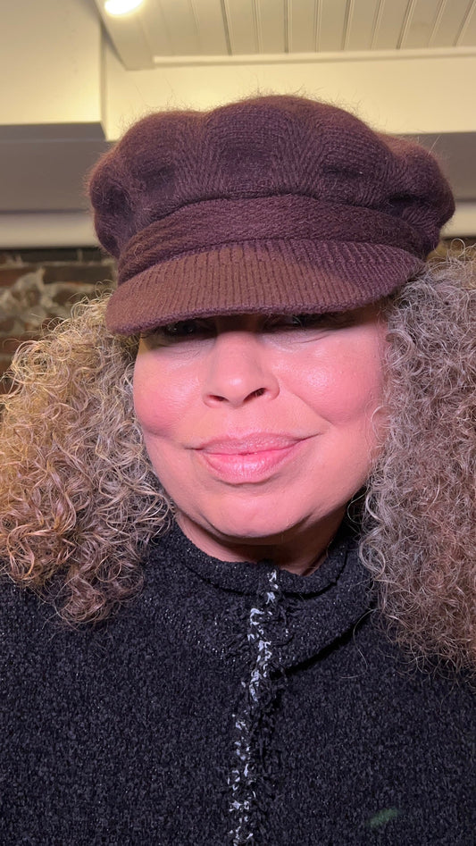 Woman with natural curly hair wearing a brown fleece-lined pageboy hat from Urban Princess Boutique, the perfect winter accessory for the 2026 Philadelphia snow storm.
