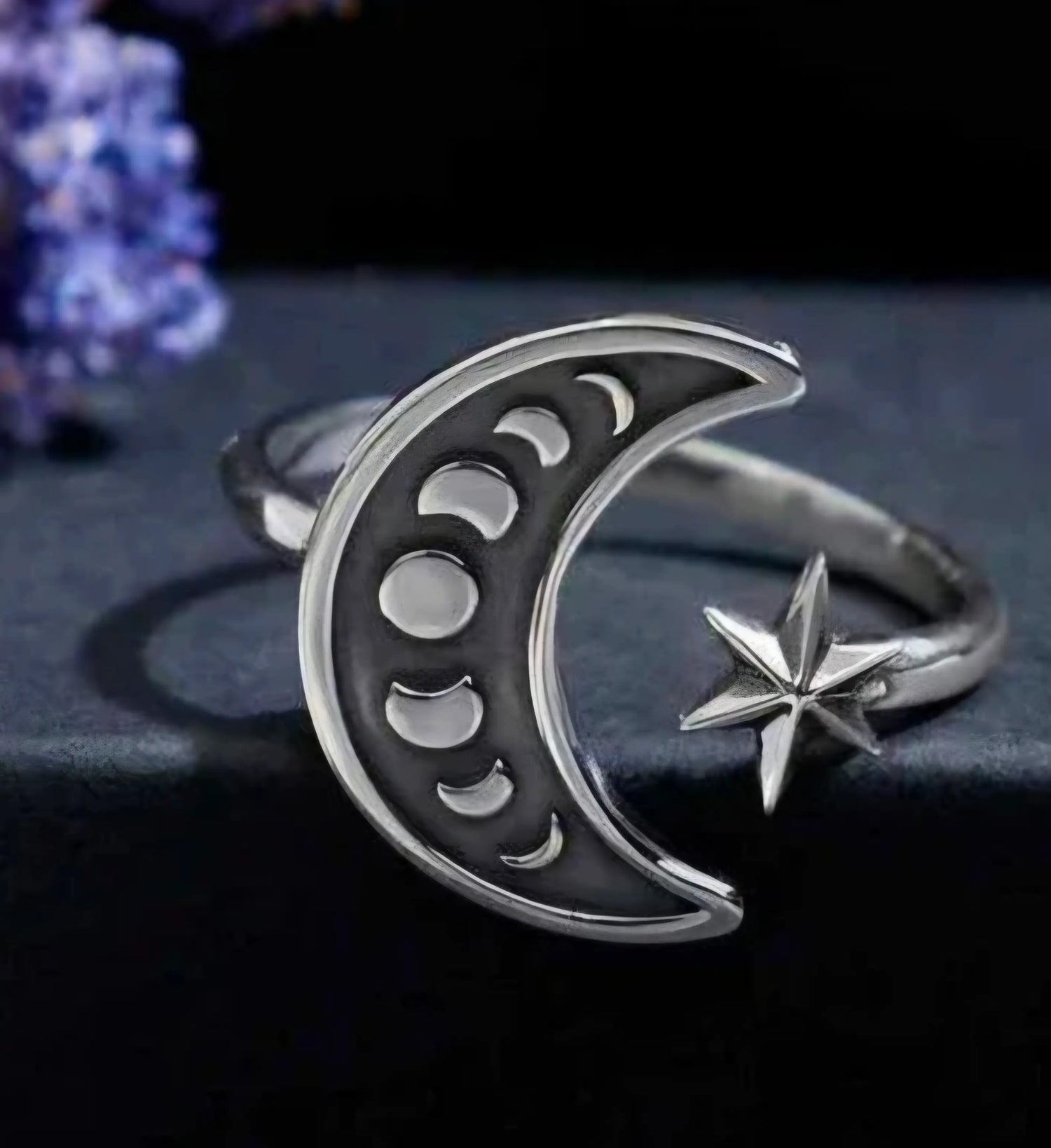 Sterling silver ring in a crescent shape with the phases of the moon etched inside.