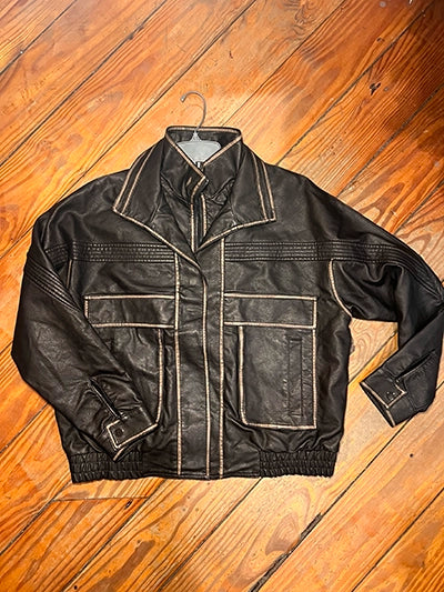 Women's oversized pocket biker jacket in brown faux leather with gold trim, flat lay