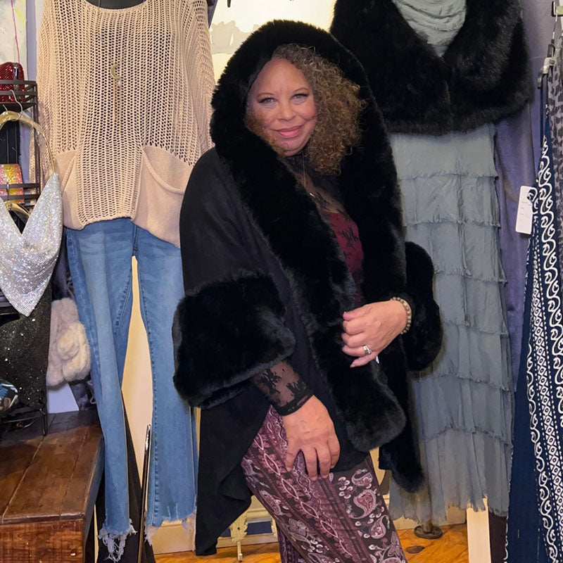 person wearing a black cape with hood pulled up