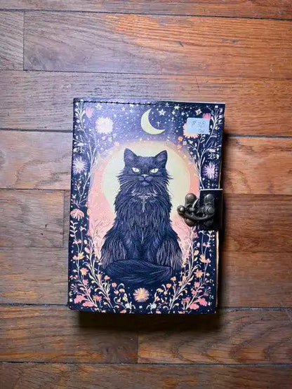 Navy journal with dark cat illustration, stars and moon, and brass clasp closure