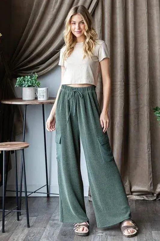 Cozy ribbed cargo pants in mossy olive green, front view. Showcased as lounge pants with a white crop top