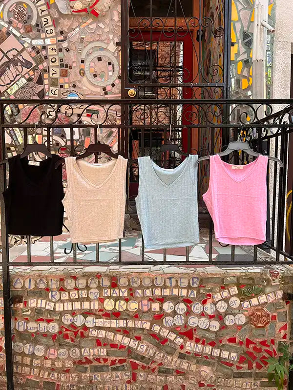 Crop tanks on rack: black, beige, light blue, and pink V-neck