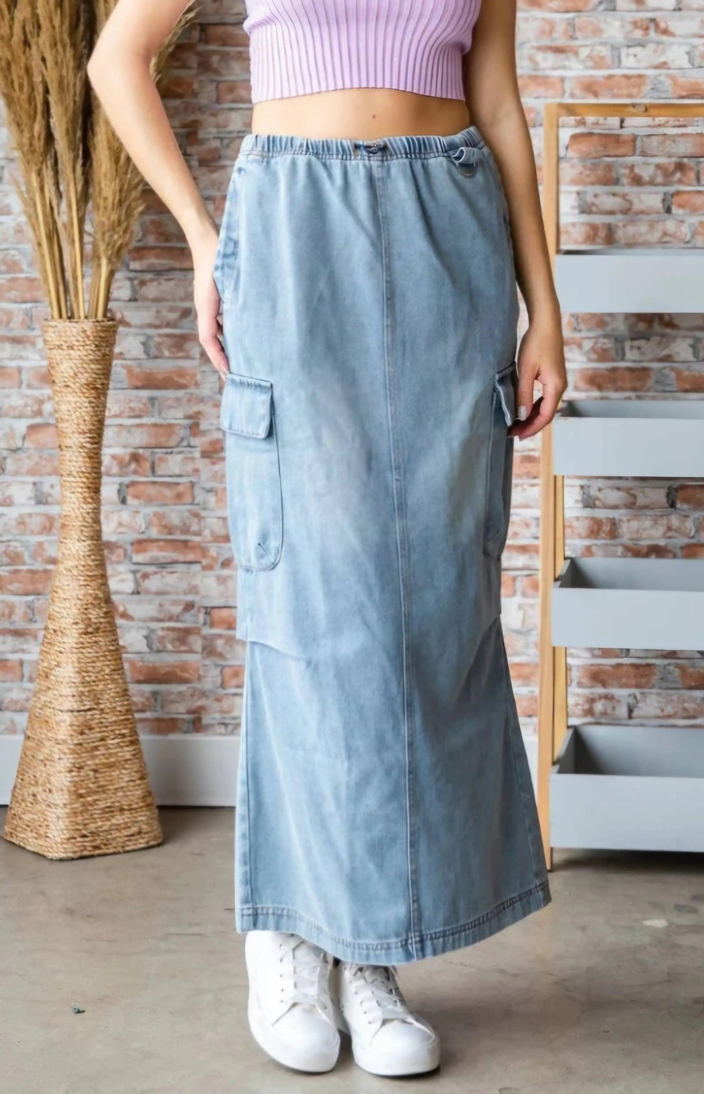 Boho denim cargo maxi skirt in soft washed light blue with elastic waist and cargo pockets, styled against a brick wall — Y2K meets coastal cowgirl aesthetic