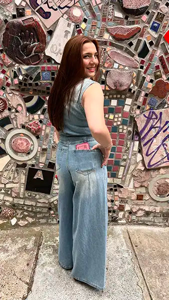 Light blue denim jumpsuit, sleeveless collar and button front with straight wide legs.