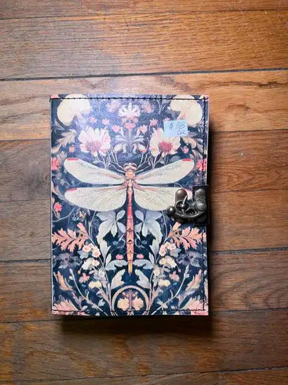 Navy journal with fantasy dragonfly wings over floral plants and brass clasp closure