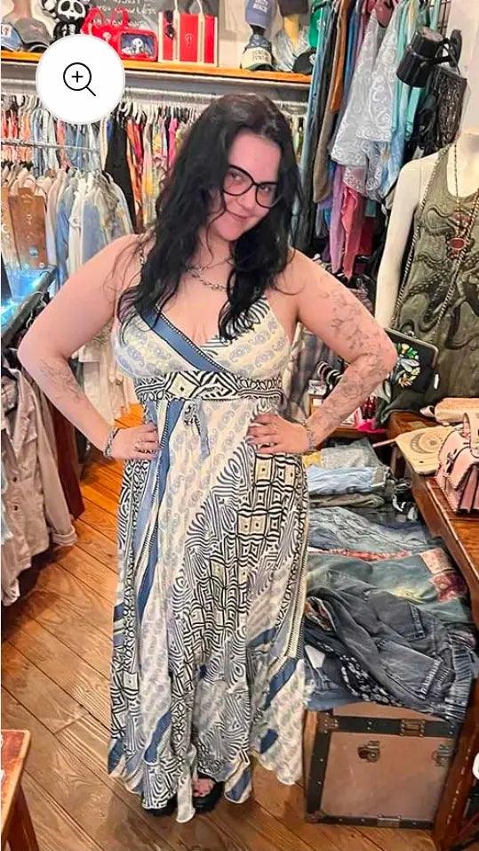 A customer trying on the blue and white long sari maxi dress inside Urban Princess so many jeans piled up next to her
