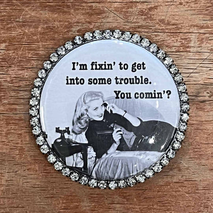 Round magnet with vintage-style image and text on a wooden surface