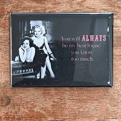 Fridge magnet with black and white photo of two women and text on a wooden surface