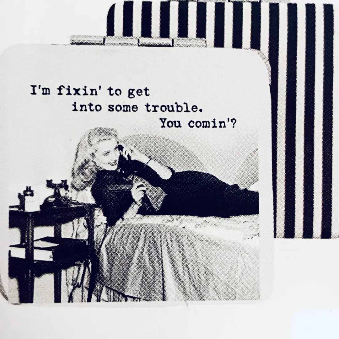 Compact mirror with vintage-style illustration of a woman on the phone and text 'I'm fixin' to get into some trouble. You comin''', against a striped background.