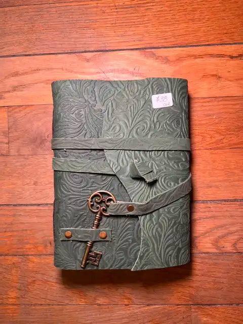 Spiritual journal cover with dark green embossed pattern and metal keys clasp