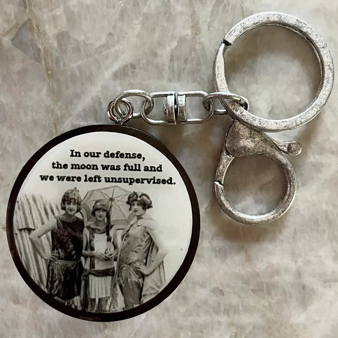 Keychain with vintage photo and humorous text on a textured surface