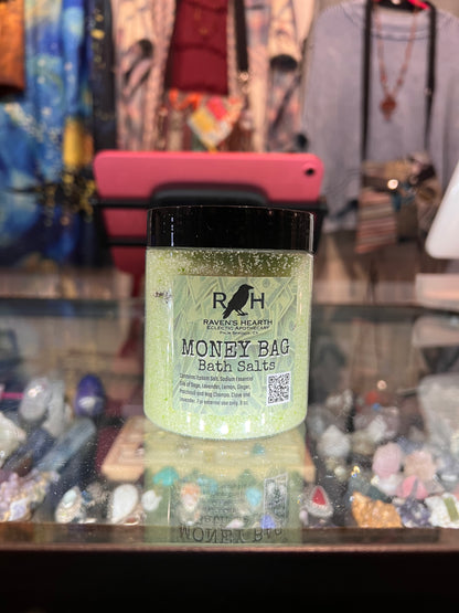 Jar of 'Money Bag Bath Salts' with a blurred store background