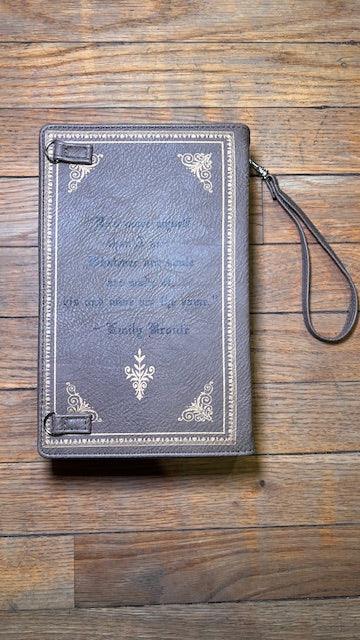 Decorative collector's book replica with wristlet strap on a wooden surface
