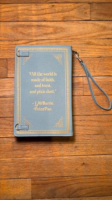 Blue book-shaped phone case with text on a wooden surface