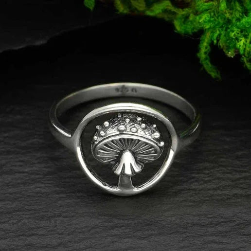 a Sterling silver ring with a detailed mushroom cut out inside a circle