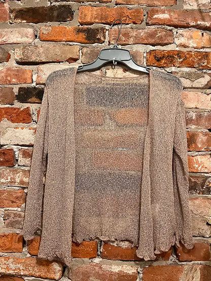 Beige textured shrug with open front, long sleeves, and scalloped hem edge.