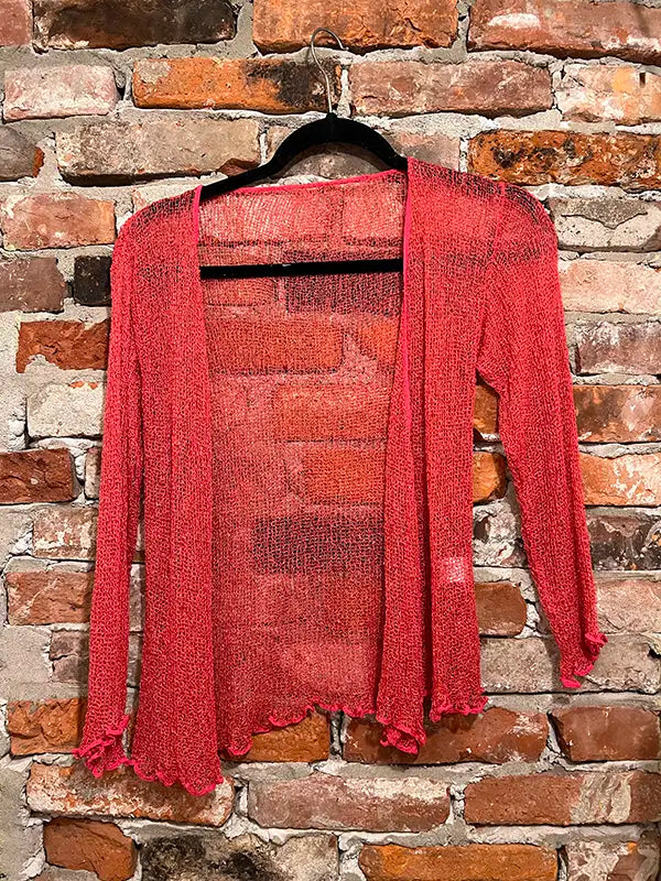 Coral textured shrug with open front, long sleeves, and scalloped edge hem.