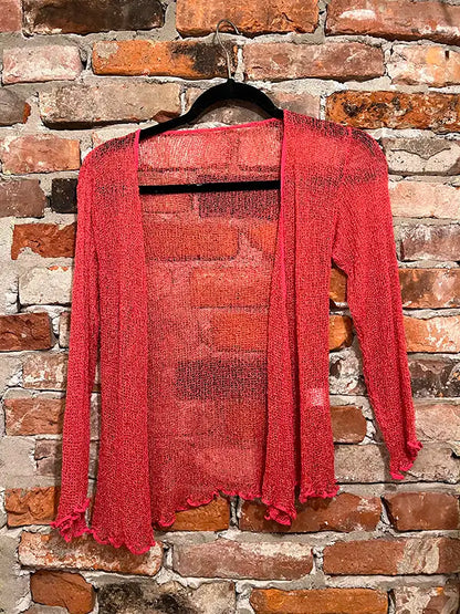 Coral textured shrug with open front, long sleeves, and scalloped edge hem.