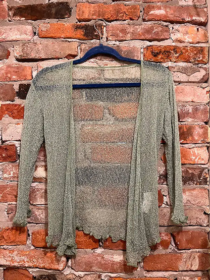 Gray-green textured shrug with open front, long sleeves, and scalloped hem.