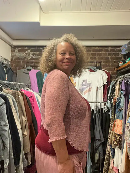Mauve knitted shrug with 3/4 sleeves and open front, scalloped hem.
