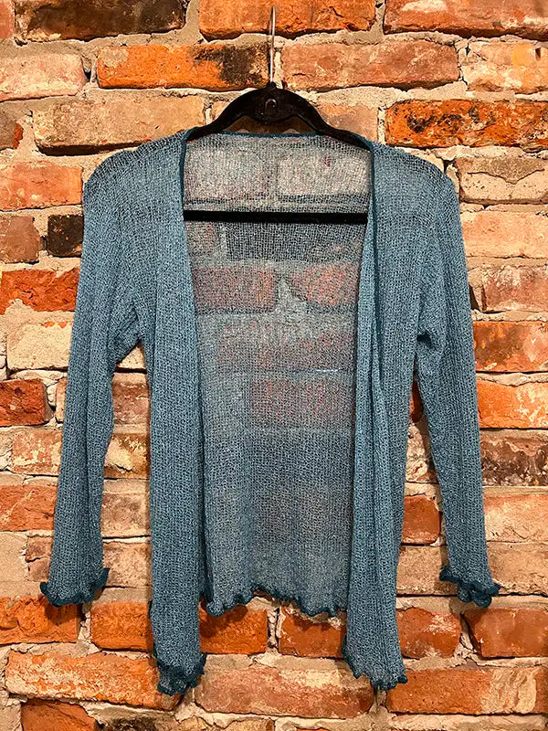 Teal textured shrug with open front, long sleeves, and scalloped hem edge.
