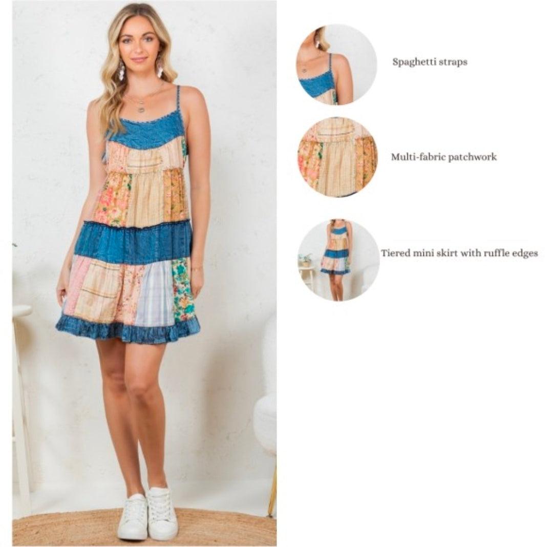 Woman wearing a patchwork dress with spaghetti straps and tiered mini skirt, on a white background. The dress is a Boho music festival outfit featuring a tiered patchwork sundress with vintage floral prints and blue denim-style lace. A breezy, colorful look perfect for summer outdoor concerts and Coachella-inspired fashion. Close up of best details