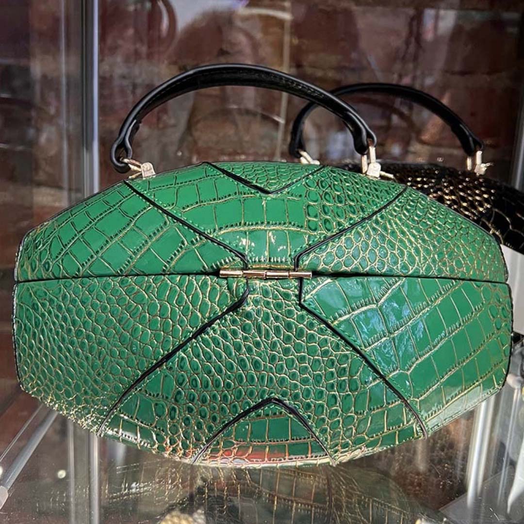 Close up shot of back of Eagles green football shaped purse on glass shelf