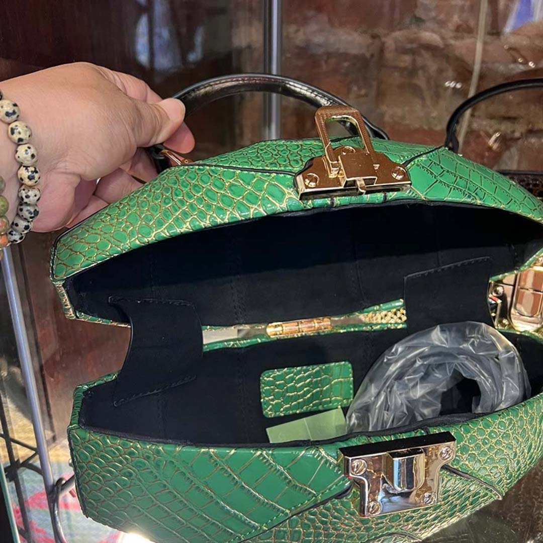 Model opening the top of the purse , showing the inside the purse.