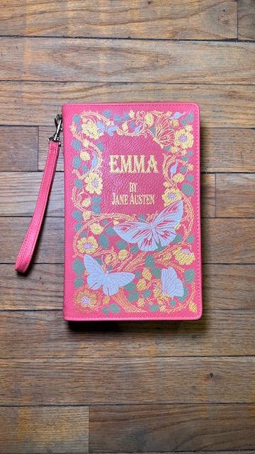 Pink book-shaped pouch with 'Emma' by Jane Austen design on a wooden surface