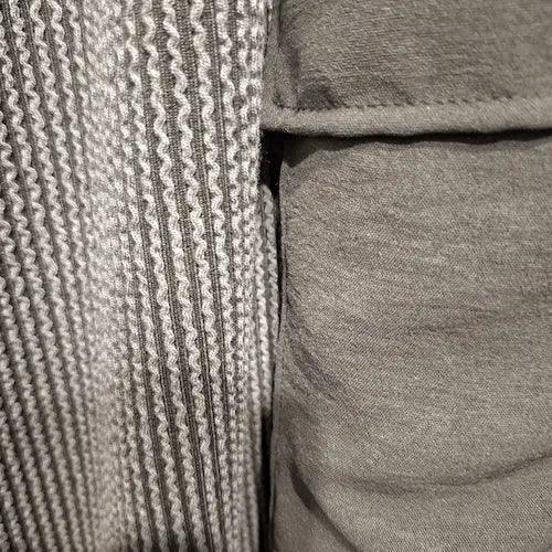 Close-up of ribbed textured fabric with a silky cargo pocket of solid olive. This could be called a soft corduroy 