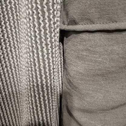 Close-up of ribbed textured fabric with a silky cargo pocket of solid olive. This could be called a soft corduroy 