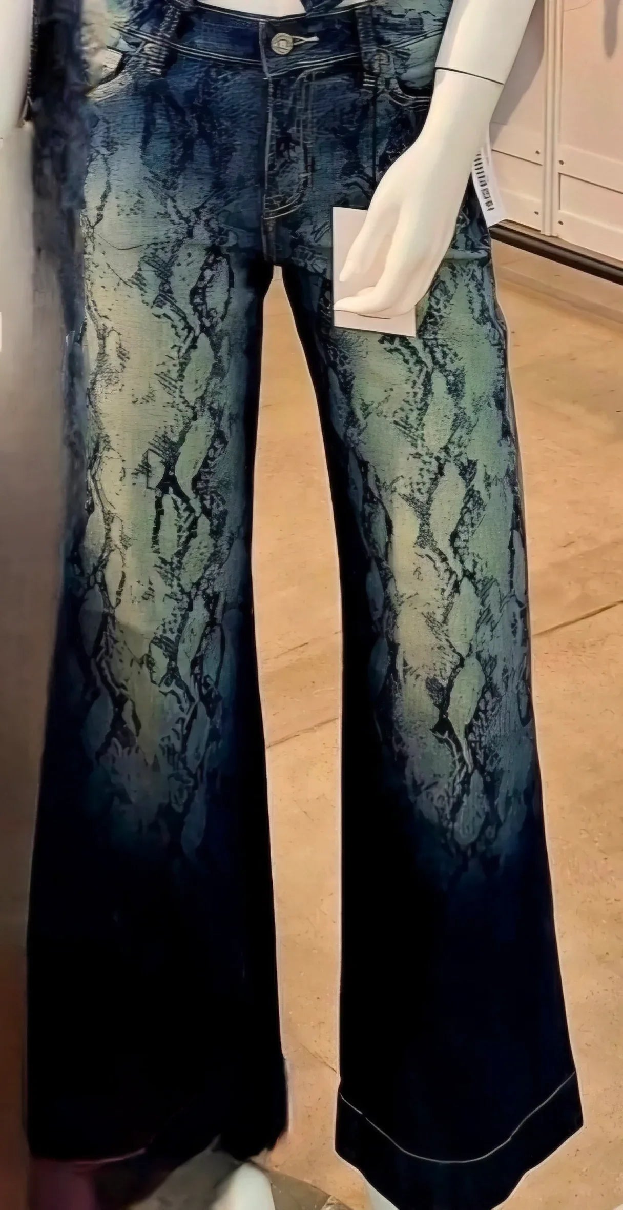 closeup of dark snake skin jeans with fading